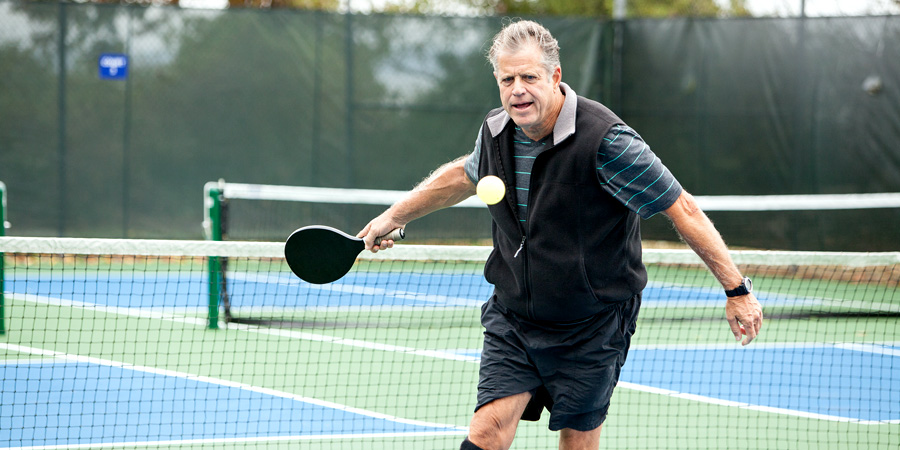 Pickleball court vs Tennis court - Senior adult playing pickleball