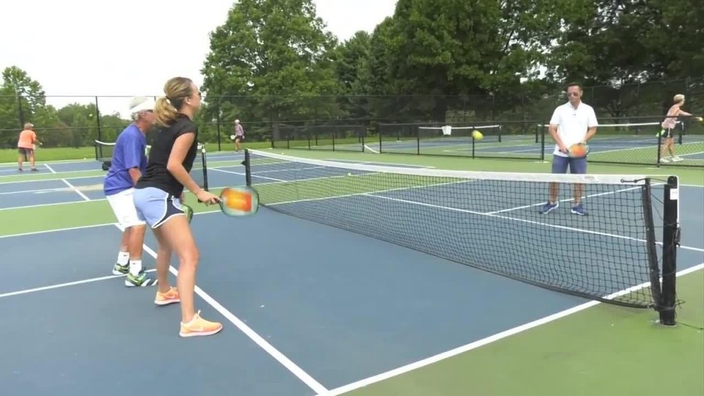 Pickleball Strategy: Tips & Techniques to Win - two players are standing together while playing pickleball 1024x576